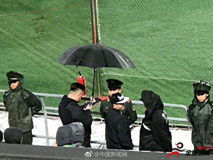 北京国安球迷在雨中为场边武警撑伞