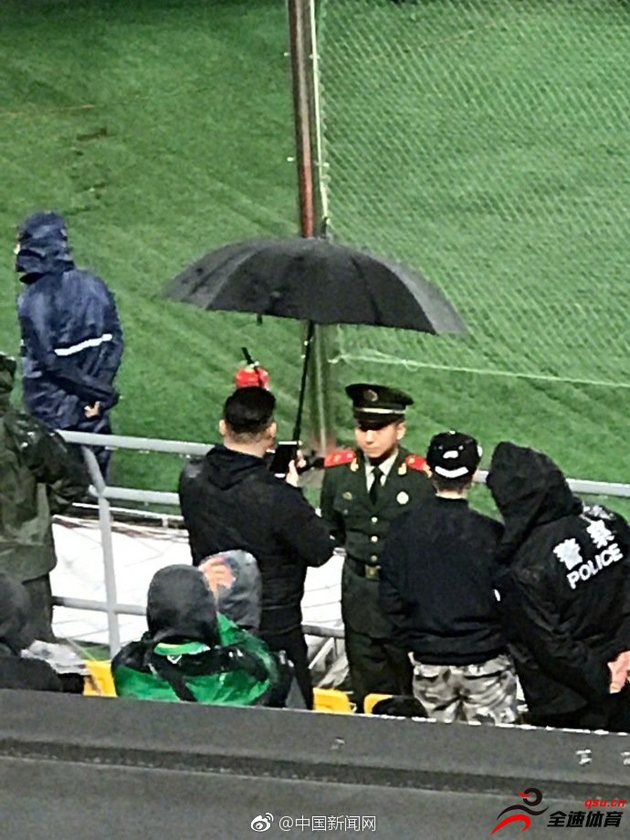 北京国安球迷在雨中为场边武警撑伞